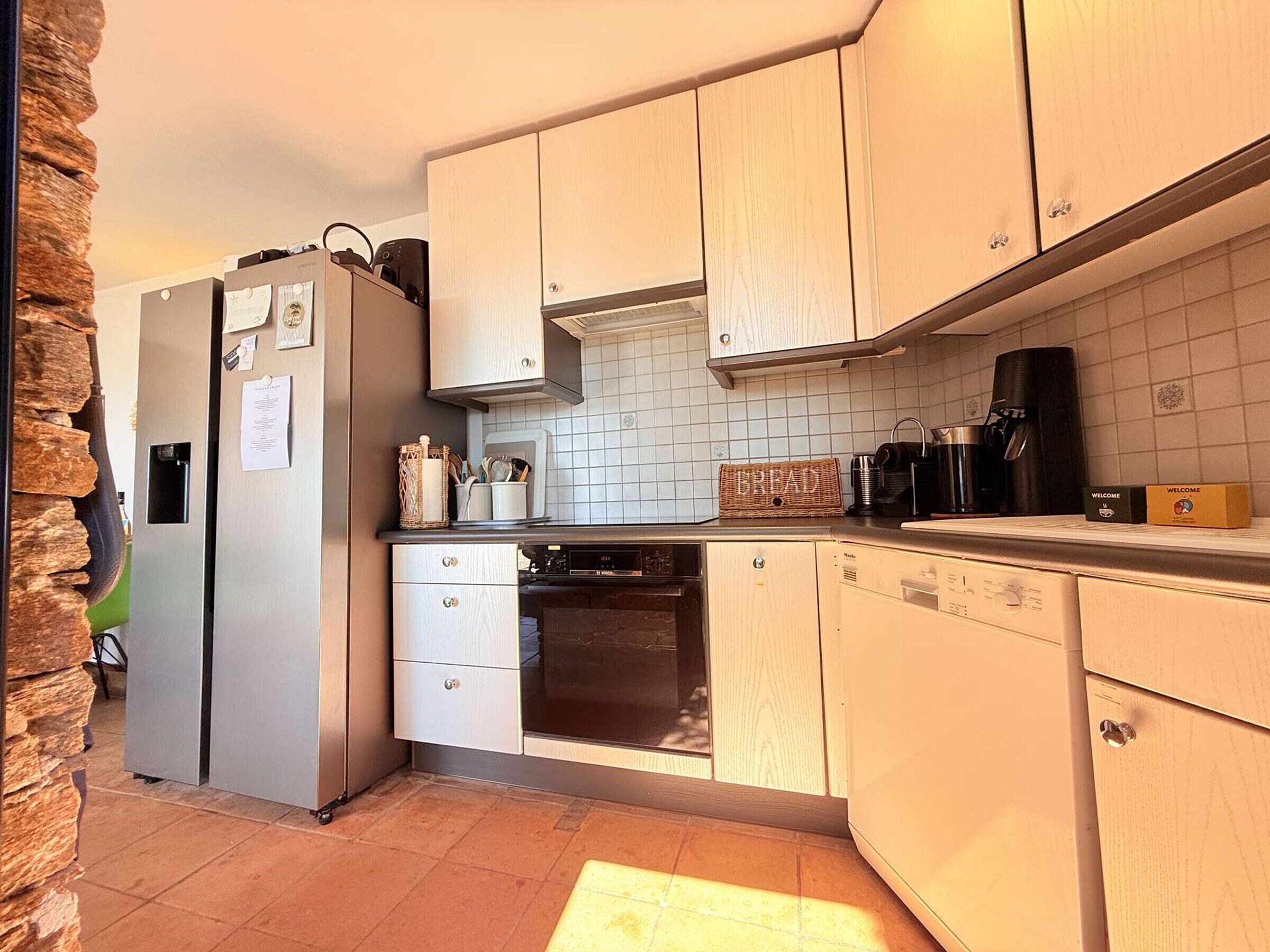 A compact kitchen with a refrigerator, oven, and coffee maker.