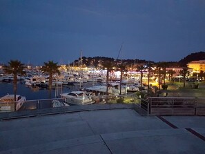 A marina at dusk with boats docked, a waterfront promenade, and buildings in the background. - Studio with parking - 4 guests in Cavalaire (Cavalaire-sur-Mer)