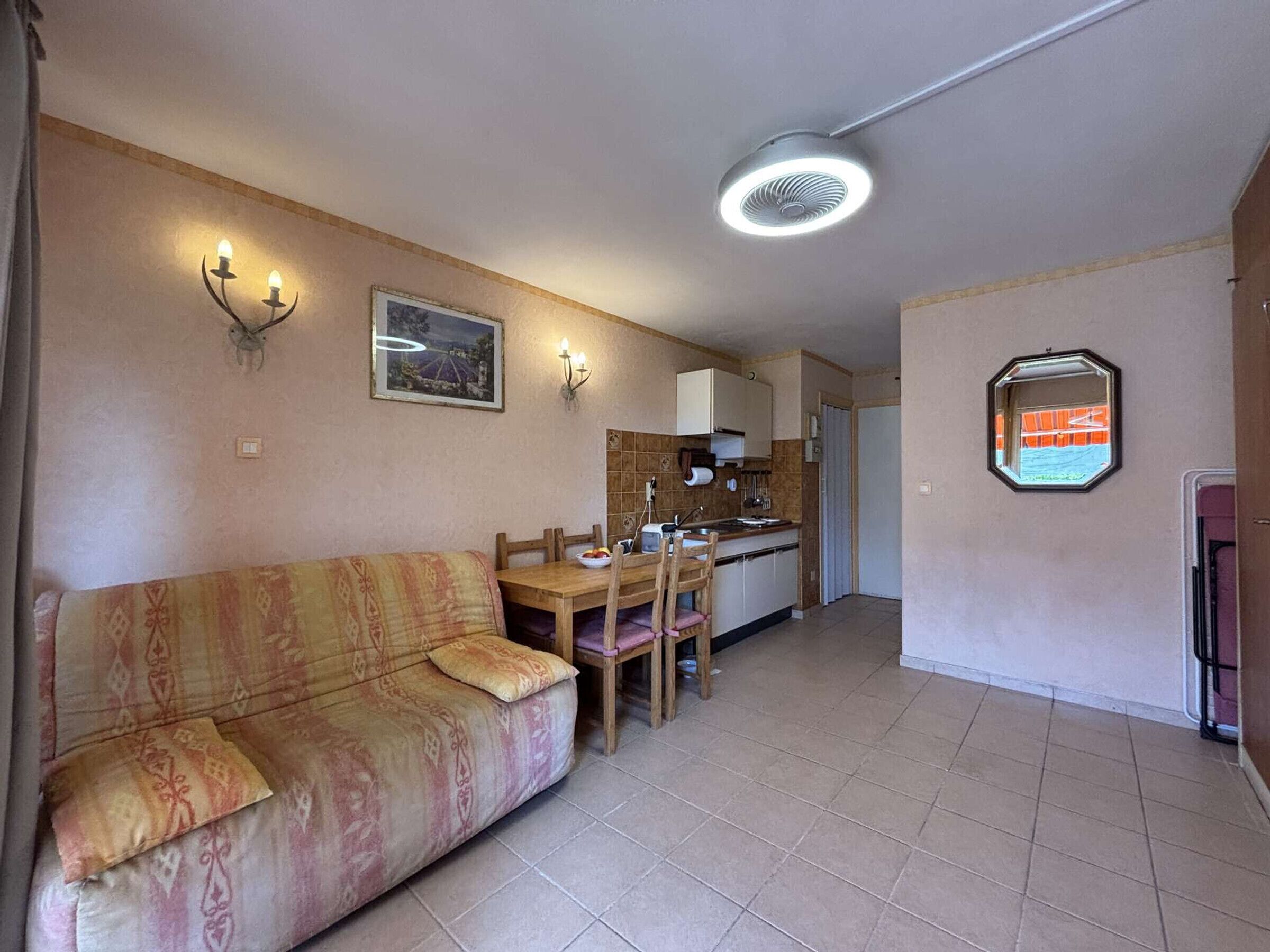 A compact living space with a sofa, dining table, and kitchenette.