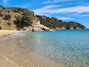 A beach with clear water, rocky cliffs, and sparse vegetation. - Studio with parking - 4 guests in Cavalaire (Cavalaire-sur-Mer)