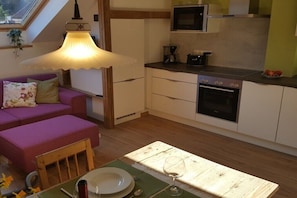 A compact kitchen with a dining area, a built-in oven, and a window above the sink. - viaDolceVita - Green Guest Apartment (Lana)