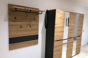 A room with a wooden wardrobe, a black hanging rod, and a white door. - Holiday apartment with 2 bedrooms (Dresden)