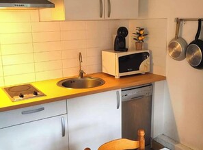 A compact kitchen with a sink, stove, microwave, and dishwasher. - Apartment with parking in city center - 3 guests (Amélie-les-Bains-Palalda)