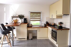 A compact kitchen with a window, a coffee machine, and a sink. - Holiday apartment with 1 bedroom (Frickingen)