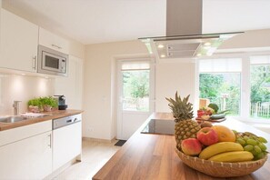 A modern kitchen with a microwave, dishwasher, and a fruit bowl on the counter. - Holiday home with 2 bedrooms (Dagebüll OT Süderwaygaard)