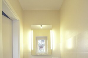 A bathroom with a mirror, a window, and a light fixture. - Holiday home with 2 bedrooms (Dagebüll OT Süderwaygaard)