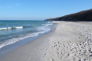 Ein Strand mit sandigem Ufer und Wellen.