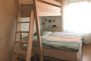 A bunk bed with a wooden ladder, a bedside table, and a wall-mounted lamp. - Holiday apartment in Rerik with swimming pool (Rerik)