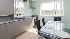 A modern kitchen with a dining area, large windows, and a view of the outside. - Aqueduct Residence (Lancaster)