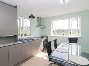 A modern kitchen with a dining area, large windows, and a view of the outside. - Aqueduct Residence (Lancaster)