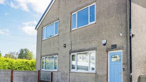 A two-story residential building with a blue door, multiple windows, and a visible address sign. - Aqueduct Residence (Lancaster)