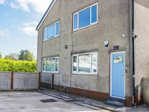 A two-story residential building with a blue door, multiple windows, and a visible address sign. - Aqueduct Residence (Lancaster)