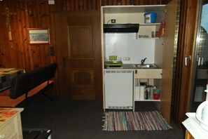 A compact kitchen with a refrigerator, sink, and a small countertop. - in the Landfrieden House (Leutasch)
