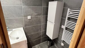 A bathroom with a white sink, a toilet, a cabinet, and a towel rack. - Spacious apartment - 6 guests (Valloire)