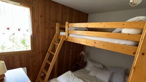 A bunk bed with a wooden ladder, a bedside table, and a window with curtains. - Spacious apartment - 6 guests (Valloire)