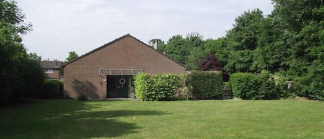 A single-story brick building with a green lawn in front.