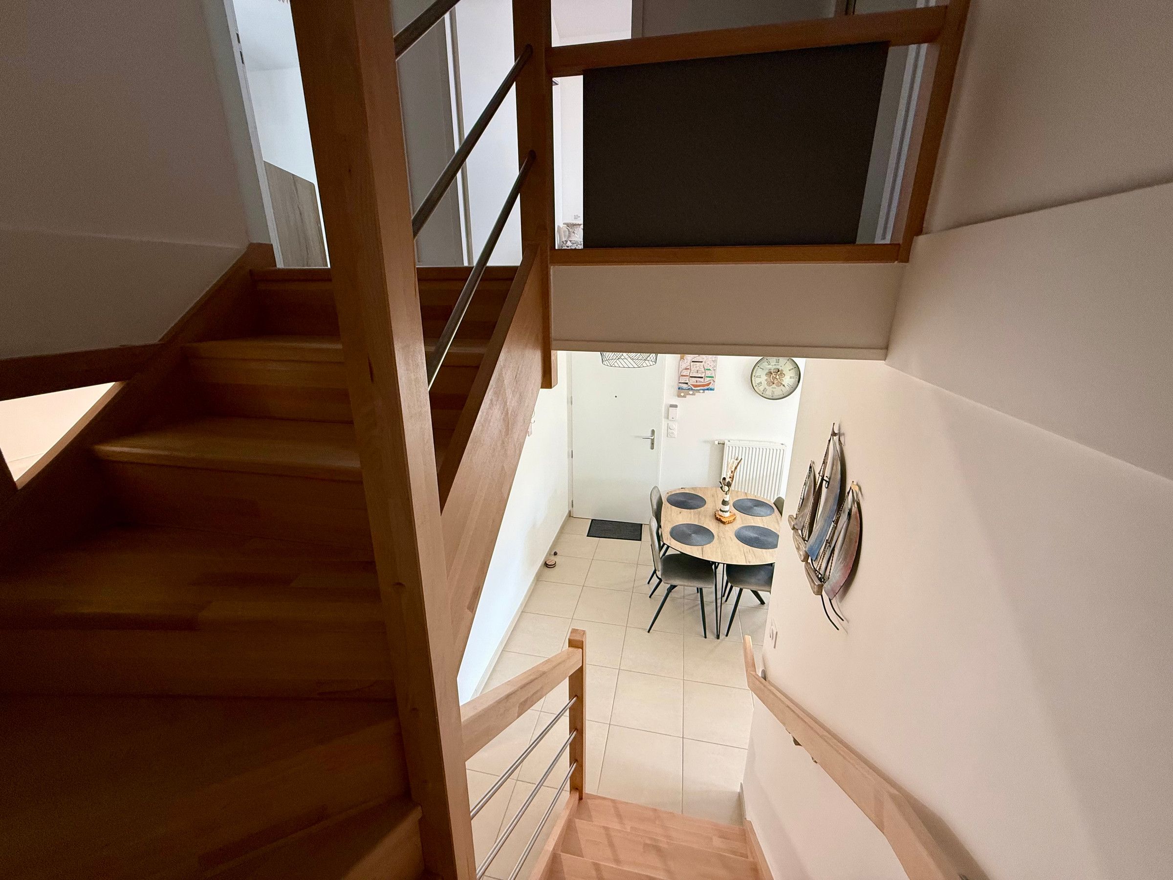 Eine Treppe führt zu einem Essbereich mit Tisch und Stühlen.