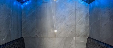 A spa room with a hexagonal ceiling, two seating areas, and a central light fixture.