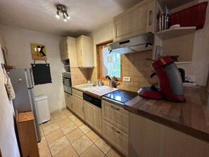 A kitchen with a refrigerator, oven, sink, and a red coffee maker on the counter. - Spacious chalet near slopes - 10 guests (Arêches-Beaufort)