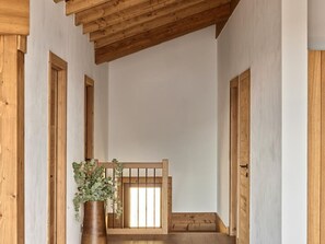 A room with a wooden ceiling, a wooden bench, and a potted plant. - Modern penthouse in center - 8 guests (Montvalezan-La Rosière)