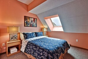 A bedroom with a bed, a nightstand, a bedside table, a lamp, a painting, and a skylight. - Mountain Green Condo 3f11 2 Bedroom Condo (Killington)