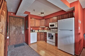 A kitchen with wooden cabinets, a refrigerator, a microwave, an oven, and a dishwasher. - Mountain Green Condo 3f11 2 Bedroom Condo (Killington)