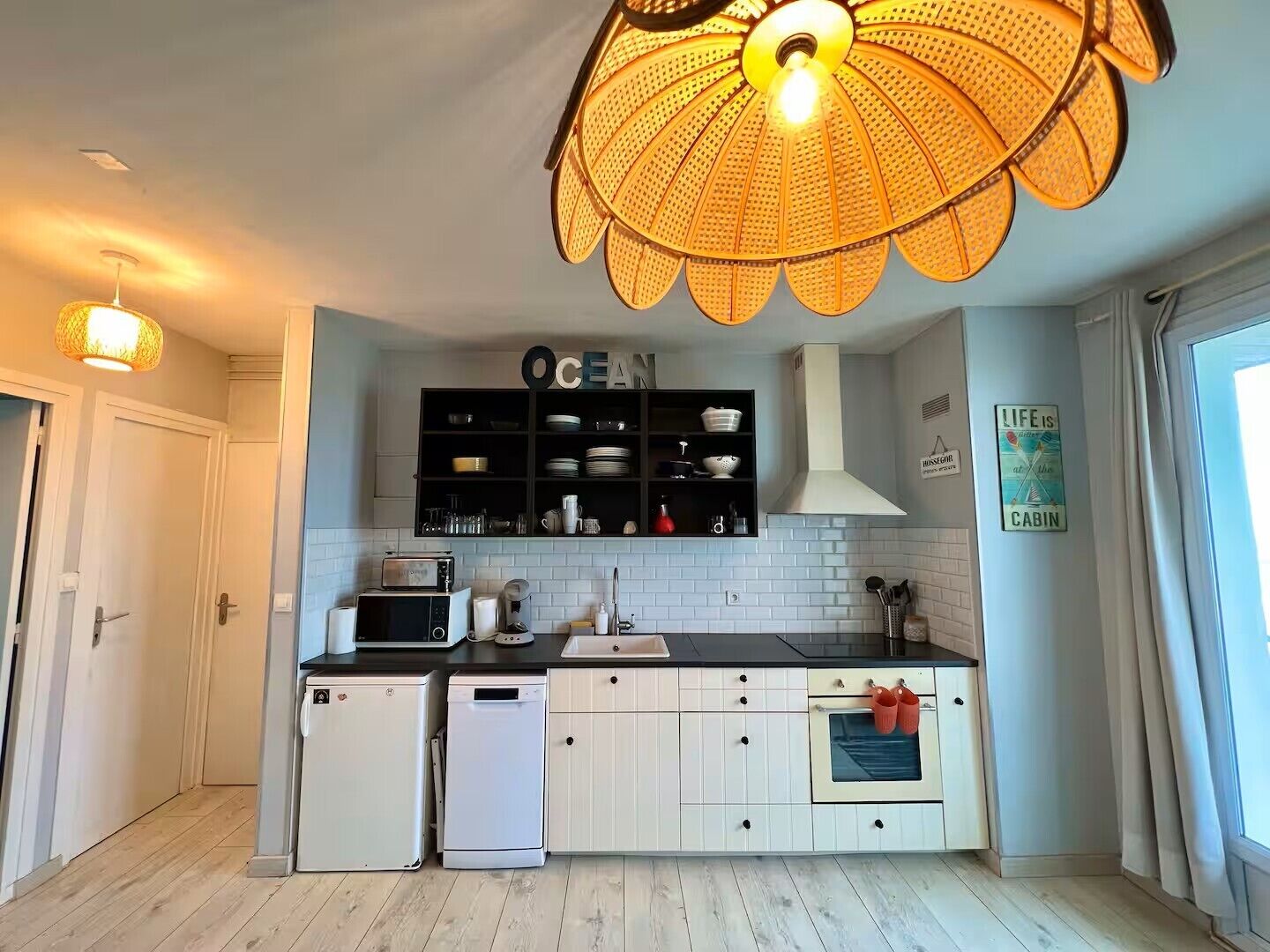 Una cucina con isola centrale, forno a microonde, tostapane, lavello e lampadario.