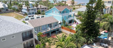 Zona residencial con varias casas, una piscina y vista al océano.