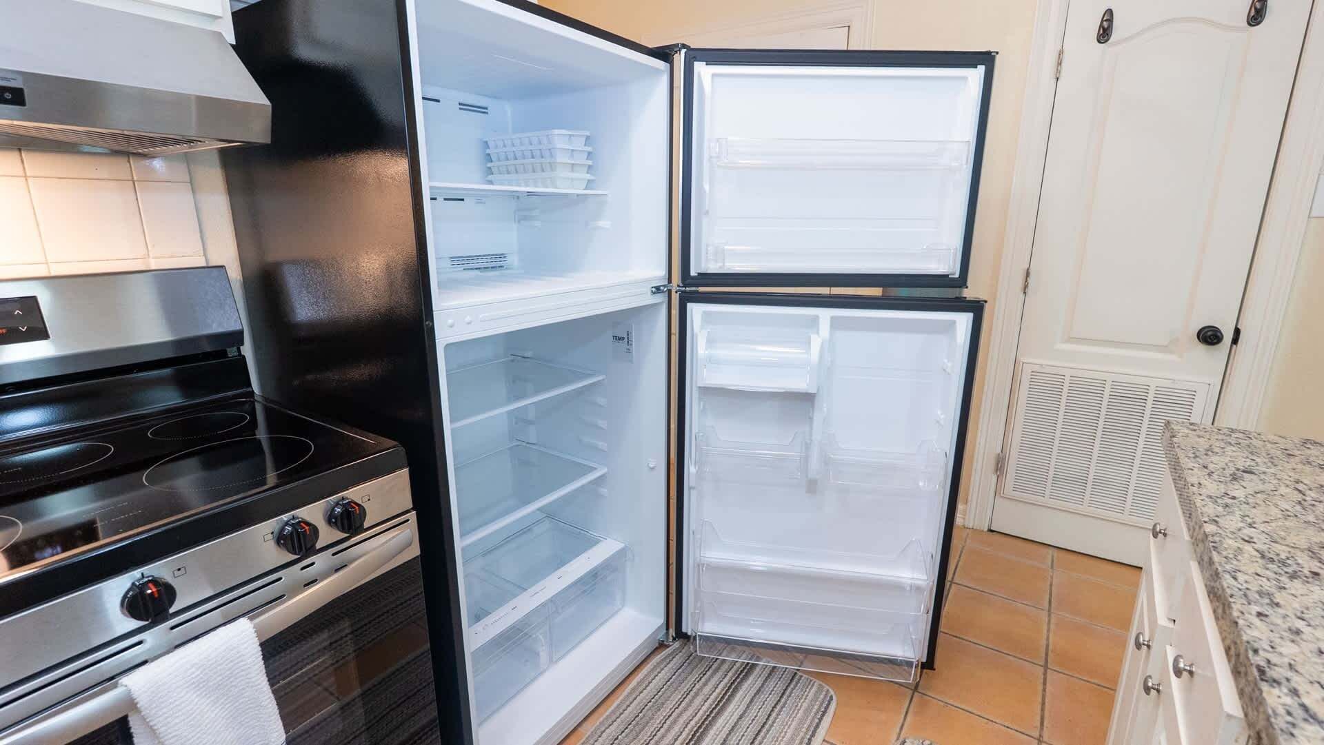 Cozinha com fogão, forno e geladeira de portas duplas.