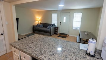 A compact living space with a kitchen area, a sofa, and a dining table.