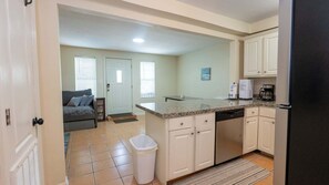 A compact kitchen with white cabinets, a granite countertop, and a dishwasher. - 2br Ground Floor, Sleeps 8, Pets Ok - Spi 2 Bedroom Apts (South Padre Island)