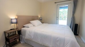Une chambre à coucher avec un lit, des tables de chevet et une fenêtre avec des rideaux.