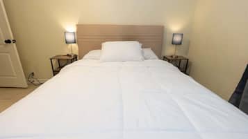 A neatly made bed with white bedding in a hotel room.