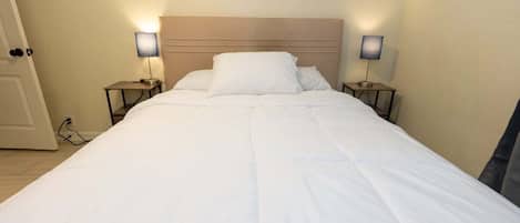 Un lit bien fait, avec du linge de lit blanc, dans une chambre d'hôtel.