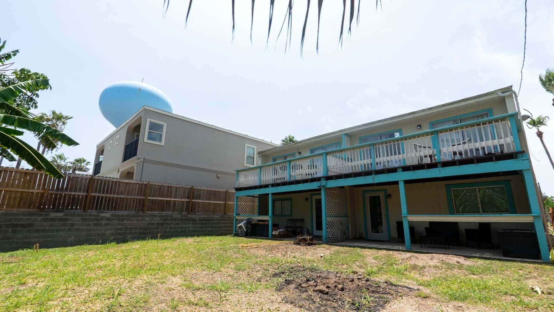 A two-story house with a balcony, a garage, and a fenced yard.
