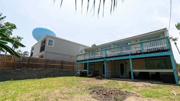 A two-story house with a balcony, a garage, and a fenced yard.