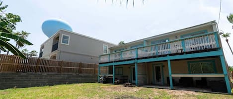 A two-story house with a balcony, a garage, and a fenced yard.