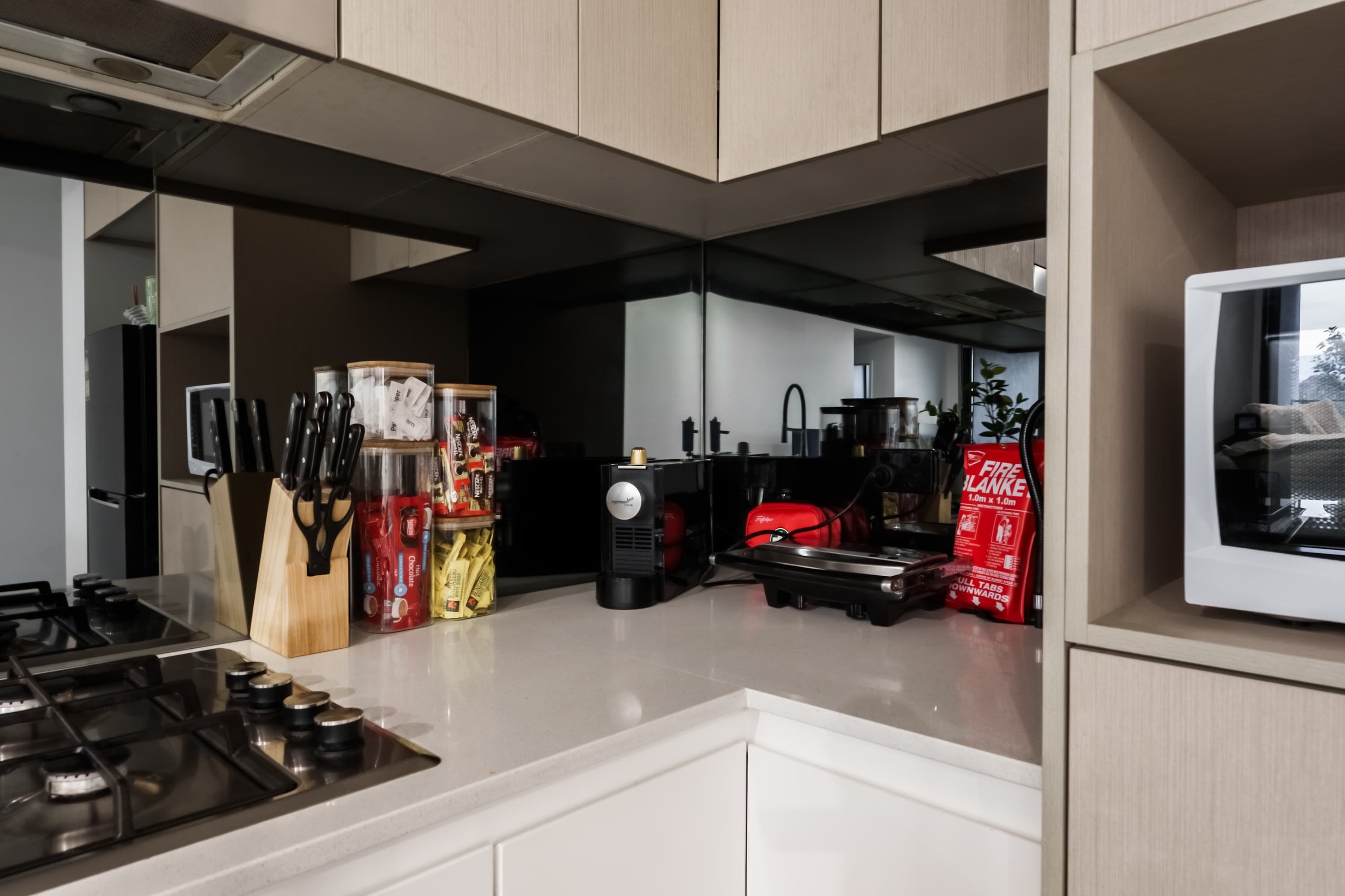 A modern kitchen with a gas stove, knife block, and various kitchen appliances.