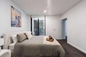 A bedroom with a bed, a painting, and a view of the outdoors. - Spiritus | Mountain View | Parking | Central (Wollongong)