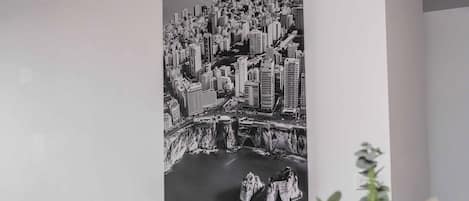Une œuvre d’art représentant un paysage urbain en noir et blanc, accrochée à un mur.