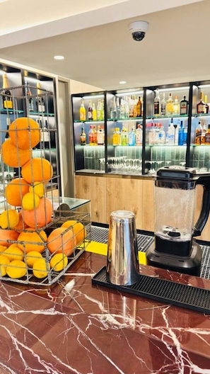A bar area with a marble countertop, a fruit display, and a variety of liquor bottles. - Lux 1 Bed w Balcony Gym Pool in Cape Town CBD (Cape Town)