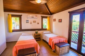 A room with two beds, a ceiling fan, and a window with curtains. - Casa Giada - Oceanfront Villa in Praia do Forte - Private Pool and 4 Suites (Acu da Torre (Praia do Forte))