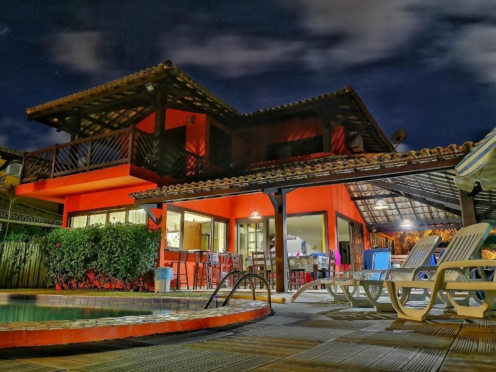 A two-story building with a covered patio area, a swimming pool, and lounge chairs.