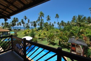 A pool area with a view of the ocean and palm trees. - Casa Giada - Oceanfront Villa in Praia do Forte - Private Pool and 4 Suites (Acu da Torre (Praia do Forte))