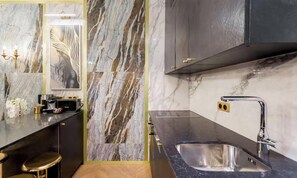 Una cocina moderna con salpicadero de mármol, electrodomésticos de acero inoxidable y un grifo elegante.