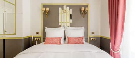 A hotel room with a large bed, two bedside tables, a mirror, and a curtain.