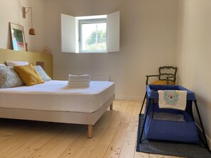 A bedroom with a bed, a window, a chair, and a small table. - Vacation rental in Haute-Loire with a pool and views of the countryside—perfect for relaxing (Paulhaguet)