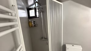 A bathroom with a shower, toilet, and a towel rack. - SimpleGreece Skyros Traditional Holiday Home with Balcony, Wi-Fi & Air Conditioning (Σκύρος)