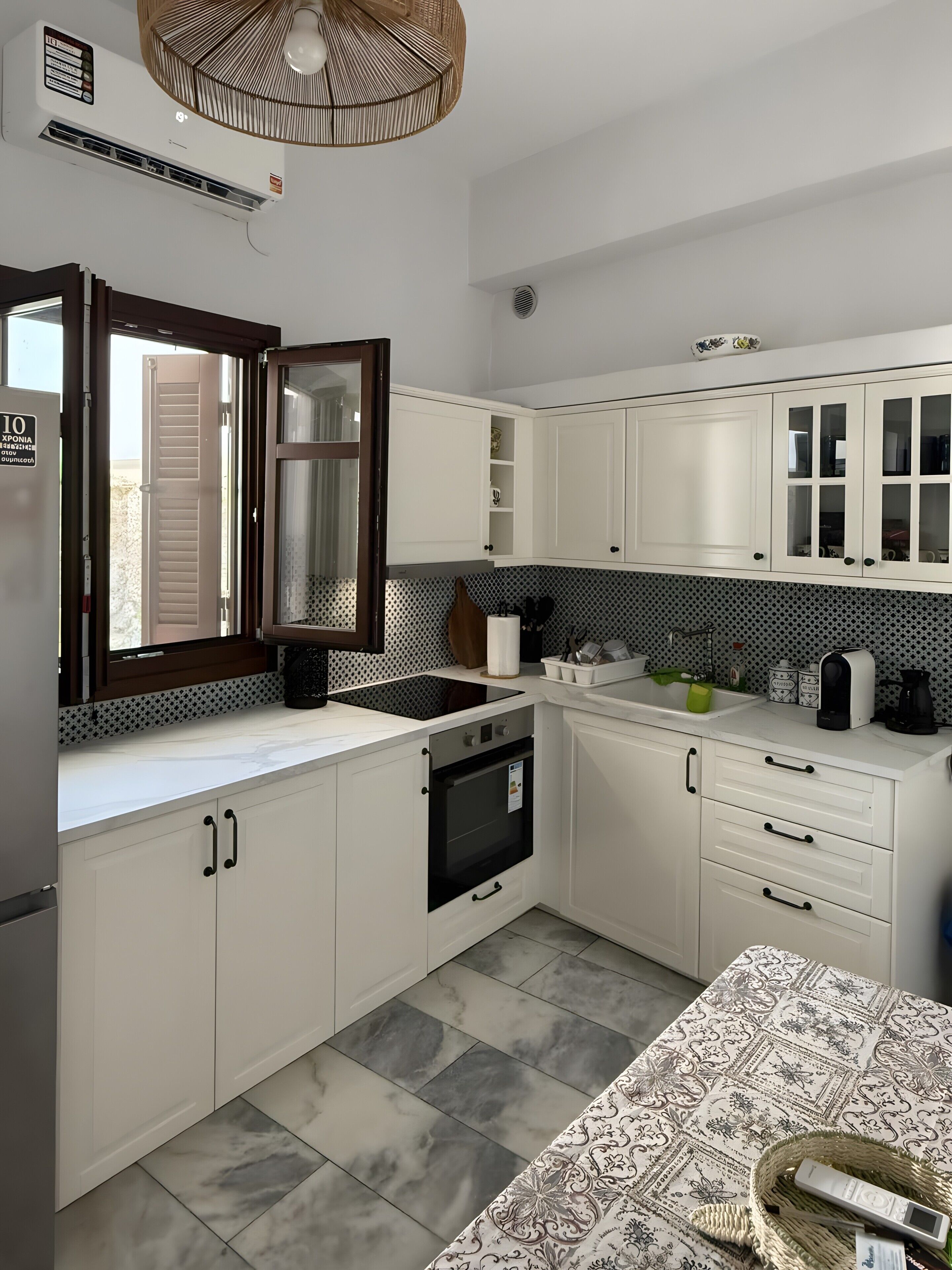 A modern kitchen with white cabinetry, a built-in oven, and a patterned backsplash.