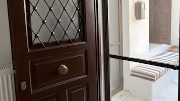 A dark wooden door with a diamond-patterned glass panel, a metal handle, and a keyhole.